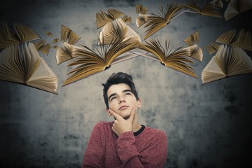 thoughtful child with books flying, imagination and creativity © carballo