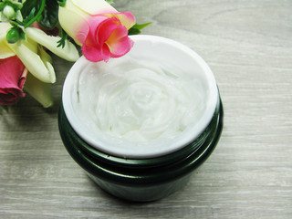 cosmetic cream for face care and rose flowers