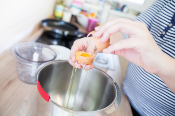 Female hands break egg