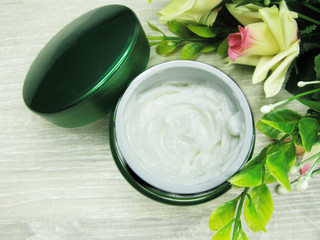 cosmetic cream for face care and rose flowers