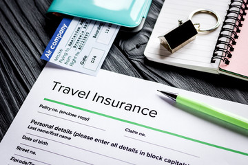 Travel insurance application form on wooden desk background