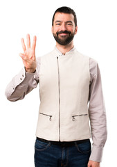 Handsome man with vest counting three on isolated white background