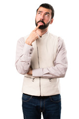 Fototapeta premium Handsome man with vest having doubts on isolated white background