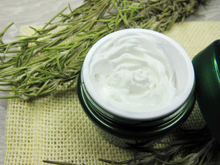 cosmetic cream for face care and rosemary leaves