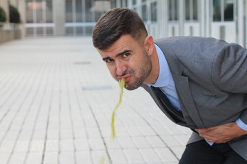 Overworked businessman vomiting at work