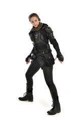 full length portrait of female  soldier wearing black  tactical armour, isolated on white studio background.