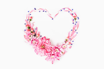 Beautiful floral arrangements. Pink chrysanthemums in the shape of heart frame on white background. Flat lay, top view.