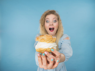 Funny woman holds cream puff cake