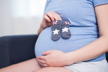 close up of pregnant belly and little socks