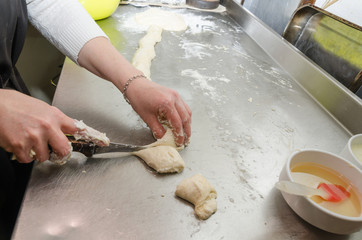 Women are making pies on the kitchen counter.