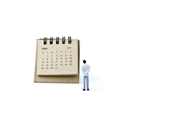 May. Calendar sheet and miniature plastic man on white background.