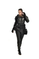 full length portrait of female  soldier wearing black  tactical armour, isolated on white studio background.