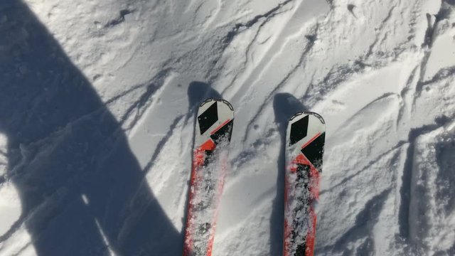 Above view of legs on ski gliding fastly over snow trace