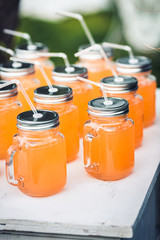 Orange juice in cans with straws.