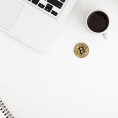 Bitcoin, coffee , plant and laptop computer on office desk flat lay. Modern business concept.