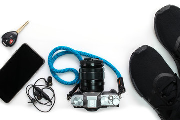 Camera and other travel accessories such as mobile phone , car key isolated on white background , top view with copy sapce
