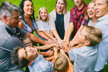 Happy family with nine children heaping hands