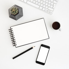 White desk, table with spiral notebook, coffee, cactus and smartphone screen for mock up or product monage. Flat lay.