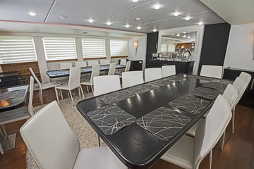 Interior of large salon dining area of luxury motor yacht