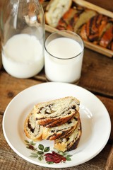 Fresh baked poppy seed roll and milk on the table  