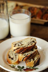Fresh baked poppy seed roll and milk on the table  