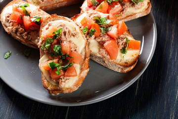 Appetizer bruschetta with tuna, mozarella cheese and tomatoes