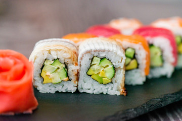 Rainbow sushi roll on tray with ginger close up