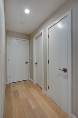 Hallway features ivory cabinets and taupe walls
