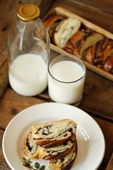 Fresh baked poppy seed roll and milk on the table 