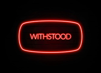Withstood neon sign on brick wall background.