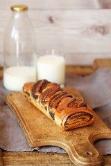 Fresh baked poppy seed roll and milk on the table  