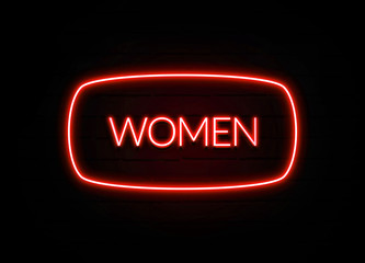 Women neon sign on brick wall background.
