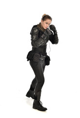 full length portrait of female  soldier wearing black  tactical armour, isolated on white studio background.