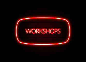 Workshops neon sign on brick wall background.