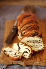 Fresh baked poppy seed roll on the table  