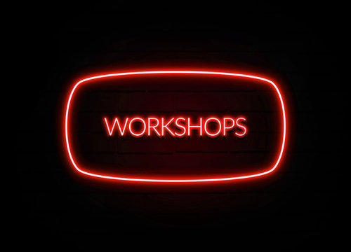 Workshops neon sign on brick wall background.