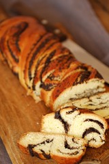 Fresh baked poppy seed roll on the table  