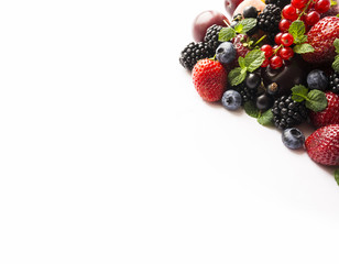 Mix berries on a white. Berries and fruits with copy space for text. Black-blue and red food. Ripe blackberries, blueberries, strawberries, currants and plums on white background. Top view.