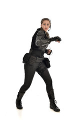 full length portrait of female  soldier wearing black  tactical armour, isolated on white studio background.