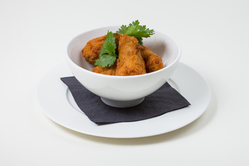 Fried Food in a white bowl on a white plate on a white background