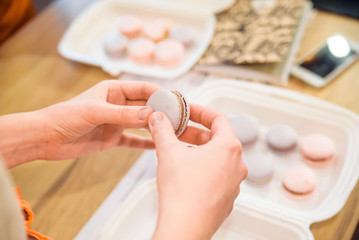 Female hands put together French macaron