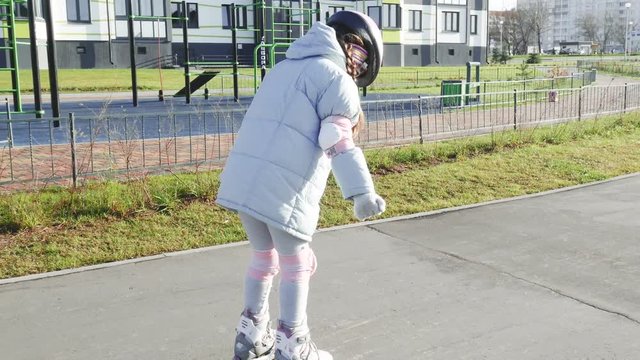 Little girl roller skating between cones
