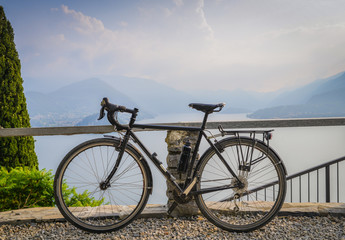 Touring bicycle next to railing with the beautiful view of Lake Como, Lombardy, Italy towards...