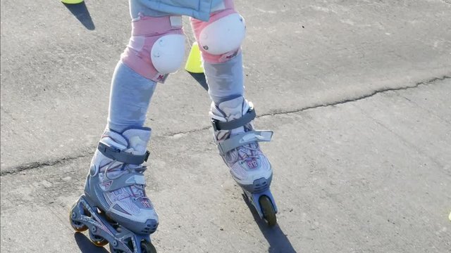Little girl roller skating between cones