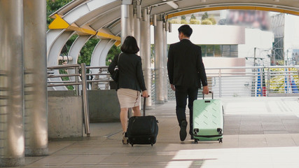 Back of business people drag baggage and walking on bridge