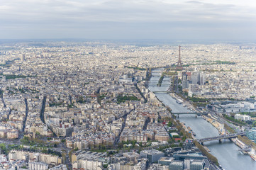 Aerial view of Paris city center with the Seine river and its bridges in the foreground and the Eiffel tower in the background.