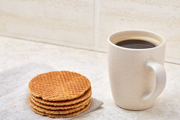 Top view closeup picture of tea in transparent cup with cookies and cotton napkin on white background, selective focus