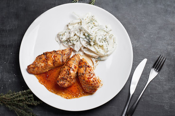 Grilled chicken fillet with vegetable salad on a slate,stone or concrete background.Top view.