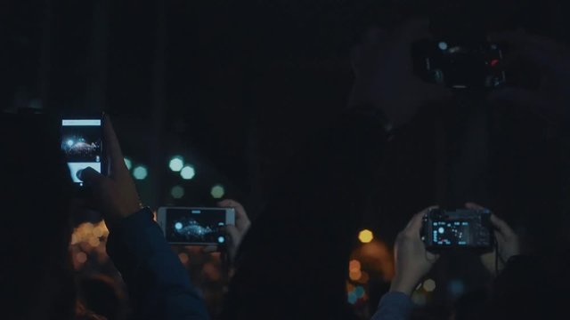 Crowd of millennials or hipsters lifestream through live applications on smartphones, record concert instead of enjoying real time event, film and photograph performace of band
