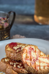 Toasts of bread with sesame seeds homemade cake in stack decorated with pine nut on white plate